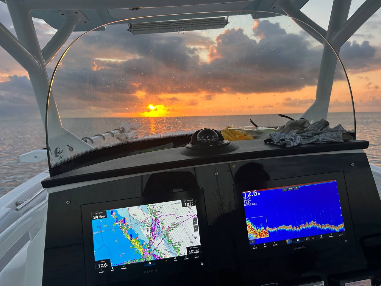 Sunrise from the helm with fish finder screens glowing offshore